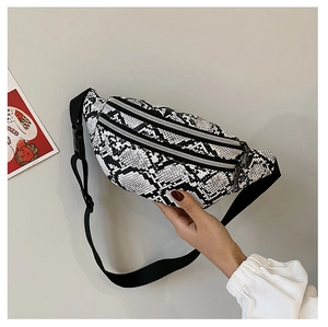 Detail of snake print waist bag with multiple zippers and adjustable strap