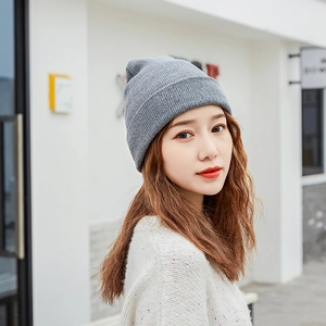 Chic women's solid grey knit beanie hat for winter, stylish street style model view