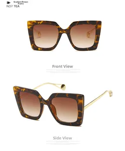Detail view of tortoiseshell oversized sunglasses with brown gradient lenses and gold temples