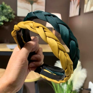 Detail of wide braided satin headbands in emerald green and ginger yellow silk-like fabric