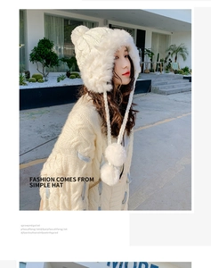 Detailed texture of white chunky knit winter hat with fluffy faux fur pom-poms