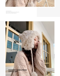 Detail of beige knit winter hat with faux fur trim and dual pom-pom tassels