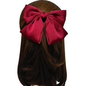 Elegant wine red satin oversized bow hair clip shown on the back of the head