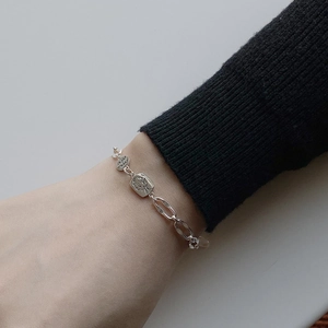 Detail of 925 sterling silver chain bracelet with rectangular portrait pendant on wrist