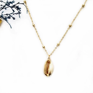 Collier bohème avec coquillage naturel, bords dorés et chaîne perlée sur fond blanc pur