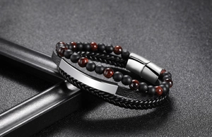 Detailed macro view of woven black leather and red tiger eye beads with silver metal clasp