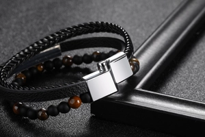 Macro shot of multi-layer black leather bracelet with brown tiger eye beads and silver magnetic clasp