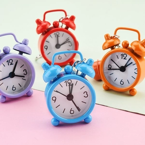 Detail view of colorful mini alarm clock keychains in purple, red, blue, and orange.