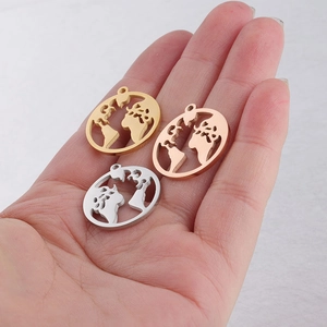 Three hollow world map pendants in gold, rose gold, and silver on a hand model