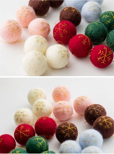 Close-up of handmade wool felt balls with gold snowflake embroidery for Xmas DIY decor
