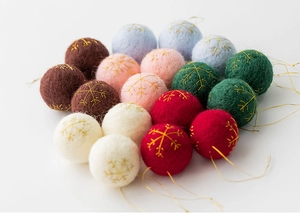 Macro view of wool felt Christmas balls with gold snowflake embroidery in varied colors