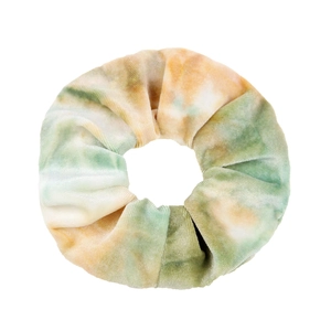 Macro view of green and orange tie-dye velvet hair scrunchie with soft fabric texture