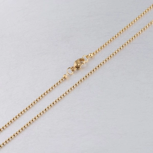 Close-up of a golden stainless steel ball bead chain with a secure lobster clasp