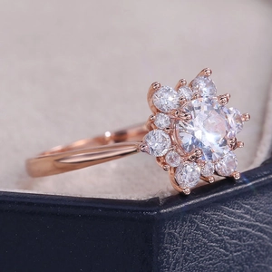 Dettaglio dell'anello a fiore in cristallo oro rosa con zirconi su scatola blu