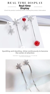 Detail of silver snowflake tassel earrings with long chains, red beads and white pearls
