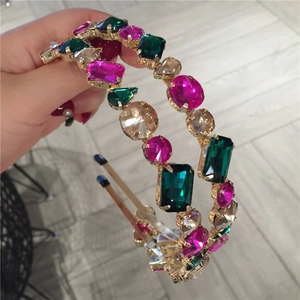 Close-up of hand-held thin gold metal headbands with colorful faceted rhinestones