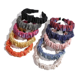 Set of 10 pleated satin and velvet headbands in assorted metallic colors on white background