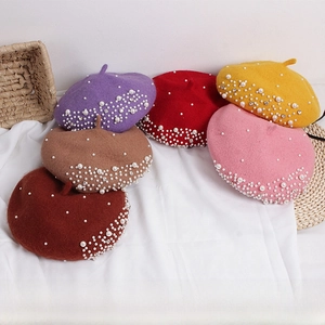 Macro shot of colorful wool berets with pearl and rhinestone embellishments for girls