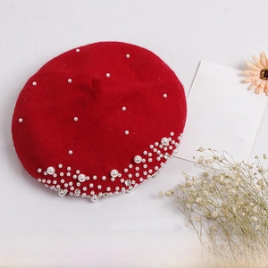 Close-up of red wool beret featuring elegant white pearls and sparkling crystal accents
