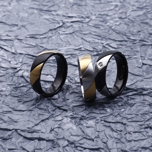 Two-tone stainless steel rings with matte and brushed finishes featuring a small diamond