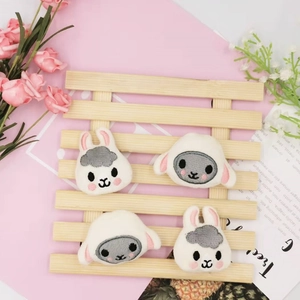 Detailed close-up of cute plush bunny and sheep brooches for DIY crafts and accessories