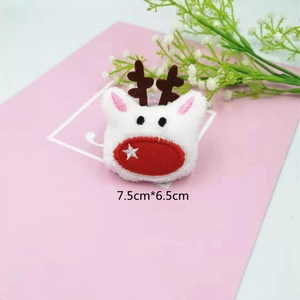 Plush Christmas reindeer accessory with antlers and red nose embroidery on pink background