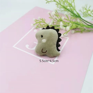 Detail of cute khaki plush dinosaur brooch with size 5.5cm by 4.5cm on a pink card