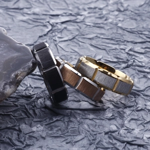 Three men's industrial style stainless steel rings in black, bronze, and gold-silver finish