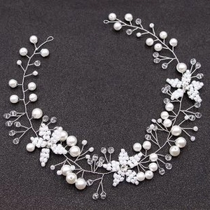 Detailed close-up of bridal headband with white pearls and crystals on silver wire
