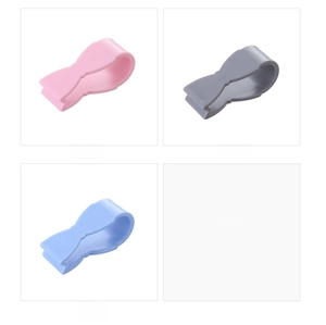 Detail of bow-shaped silicone quilt clips in pink, grey and blue minimalist colors
