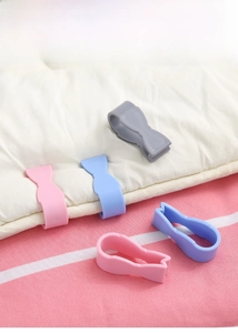 Detail showing colorful bow-shaped duvet clips holding white bedding securely in place