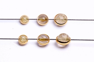Macro shot of 14k gold-filled round crystal beads with golden silk inclusions for jewelry