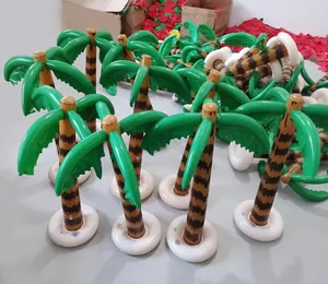 Batch of inflatable PVC palm trees with green leaves and brown trunks in production site
