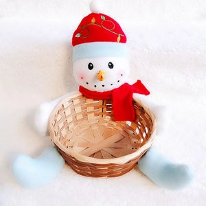 Detail of bamboo Christmas basket featuring a plush snowman with red hat and scarf