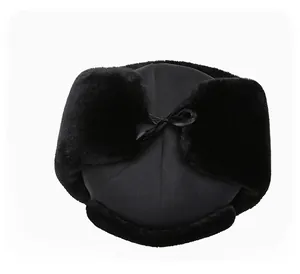 Top view of winter trapper hat with black faux fur lining and top ribbon bow tie
