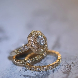 Macro shot of gold hexagon ring set with circular cubic zirconia on marble