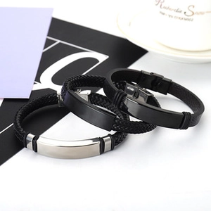 Close-up of black braided silicone bracelets with silver and black metal plates
