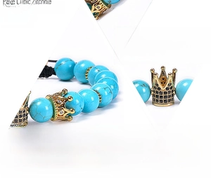 Macro detail of 8mm turquoise bead bracelet with gold crown charm and CZ inlay