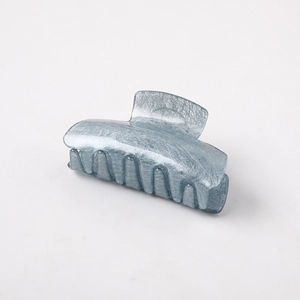 Macro detail of ice blue shark hair clip featuring premium acetate with brushed texture