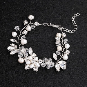Detailed close-up of floral silver bracelet with white pearls and sparkling crystals