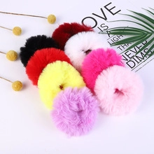 Set of 8 colorful plush hair scrunchies in various shades on a minimalist background