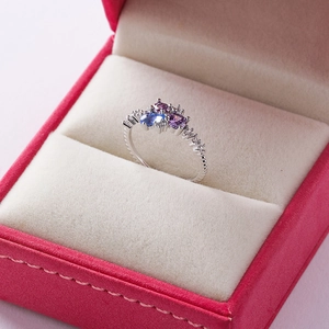 Macro view of crystal flower ring with heart gems in a red velvet jewelry box