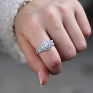 Close-up of a silver multi-layer halo ring with round-cut pavé diamonds on a hand