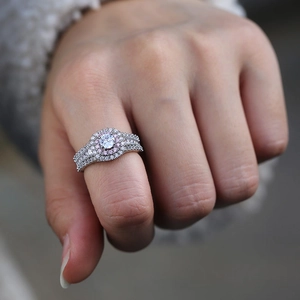 Elegant halo ring with a round center stone and a layer of pink accent diamonds on finger