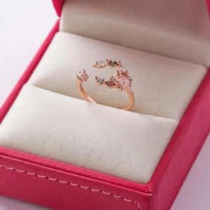 Detail of rose gold flower ring with pink gem in a velvet jewelry box