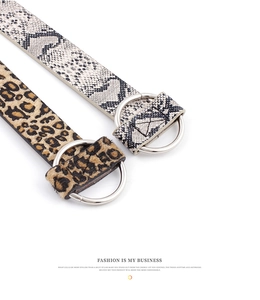 Detail of snake and leopard print belts with silver double D-ring buckles on white background