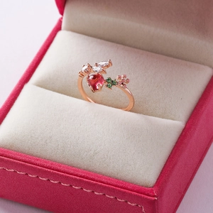 Close-up of rose gold open ring with heart-shaped pink stone and floral zircon details