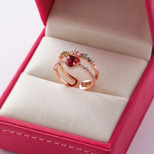 Close-up of rose gold open ring with heart-shaped red stone and floral zircon details