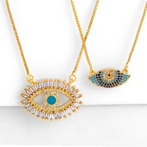 Colliers choker dorés avec pendentifs œil bleu et cristaux pavés sur fond blanc neutre