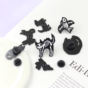 Gothic black enamel animal skeleton brooches featuring cat and bird bone designs